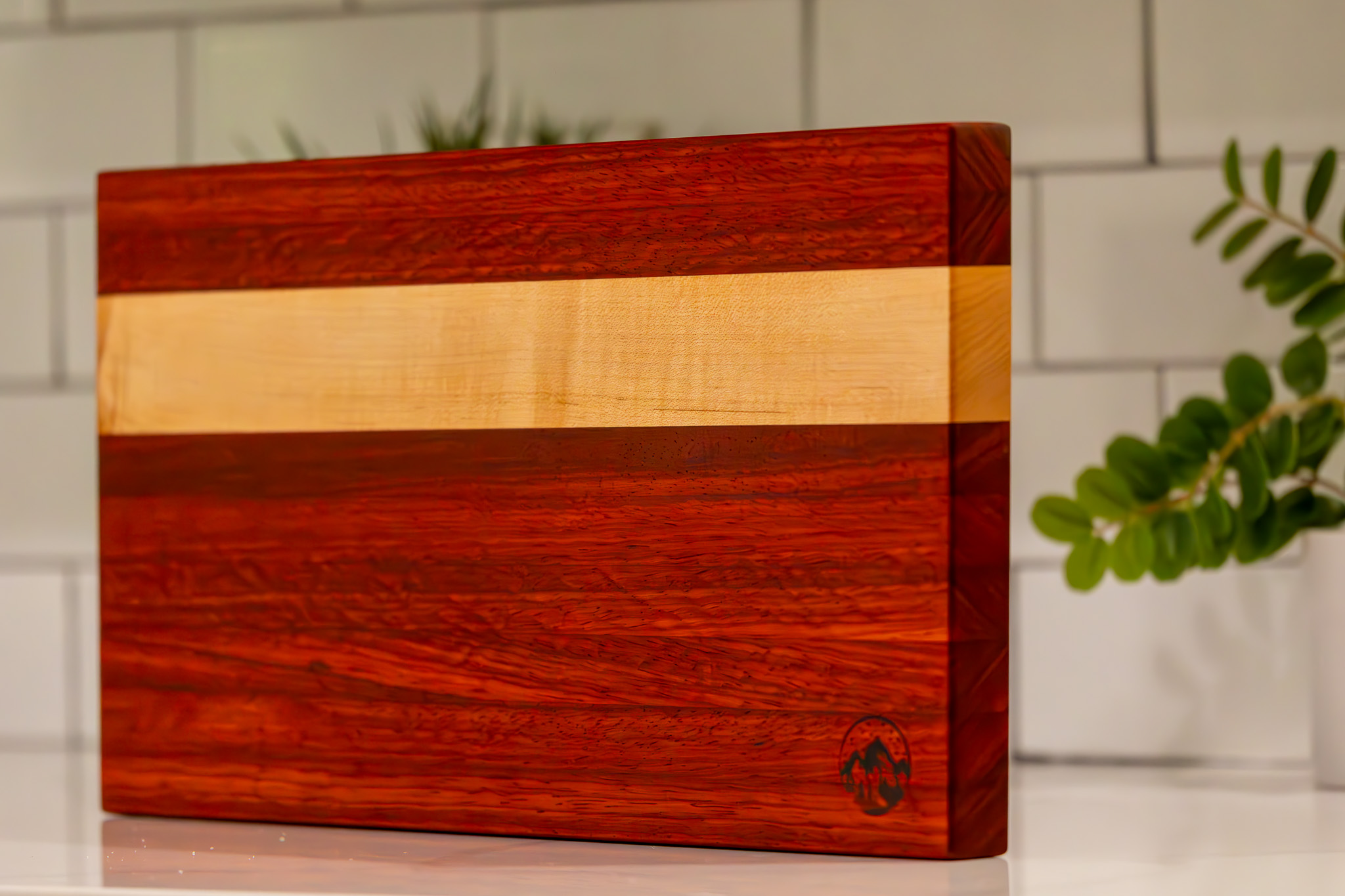 Padauk cutting board with a maple stripe